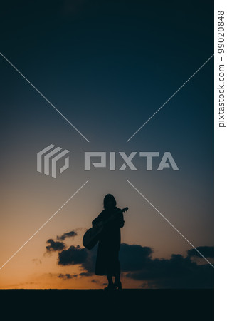 Photo of a young woman playing guitar Photo of a young woman playing guitar 99020848