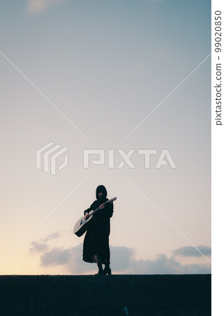 Photo of a young woman playing guitar Photo of a young woman playing guitar 99020850
