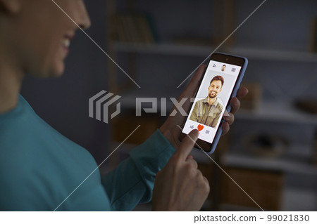 Woman looking for a boyfriend and using an online dating application on her smartphone 99021830
