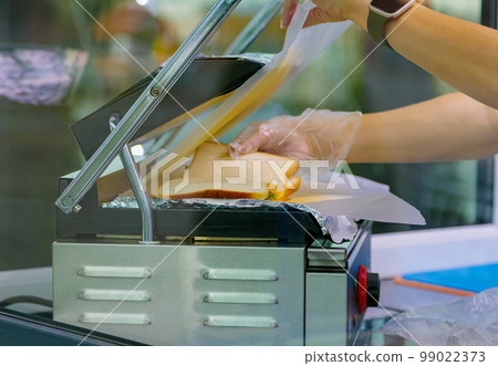 Grilling sandwiches on an electric grill. 99022373