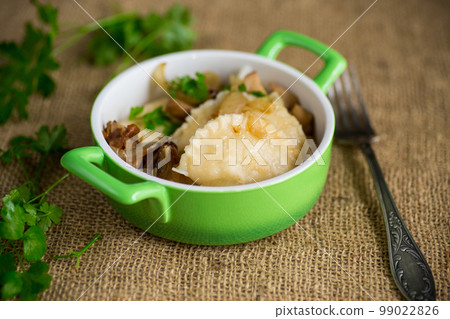 Potato dumplings with onion and mushrooms in a plate. 99022826