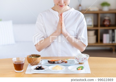 Young woman eating breakfast 99022869