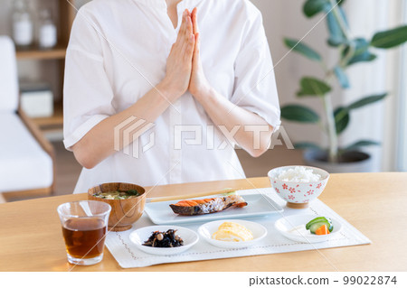 Young woman eating breakfast Young woman eating breakfast 99022874