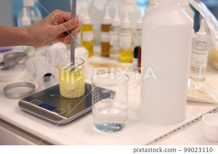 在實驗室的秤上將燒杯中的溶液與各種溶液的瓶子混合 99023110