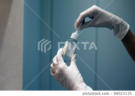 Cropped view of human hand in medical glove opening lid of container with solution in laboratory Cropped view of human hand in medical glove opening lid of container with solution in laboratory 99023135
