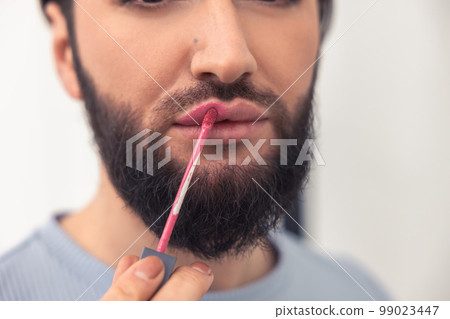 Transgender person focused on coloring his lips 99023447