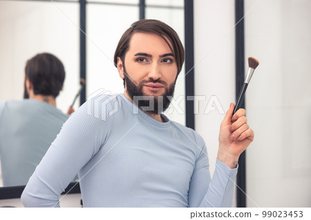 Young man daydreaming during the makeup application 99023453