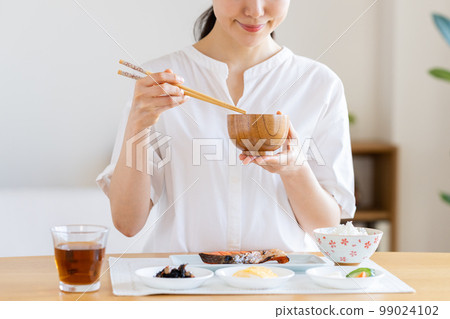 young woman eating breakfast young woman eating breakfast 99024102