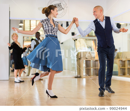 Pair dancing lindy hop during rehearsal Pair dancing lindy hop during rehearsal 99024944