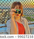 Young woman posing with a camera 99027238