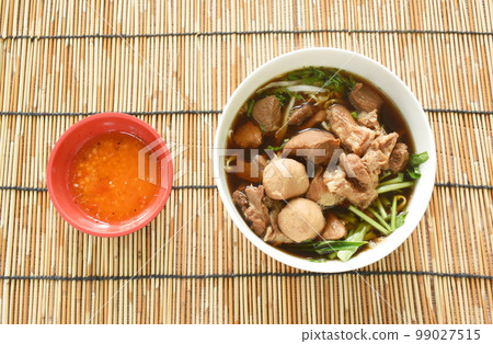 braised pork with meatball in herb brown soup on bowl and spicy chili sauce braised pork with meatball in herb brown soup on bowl and spicy chili sauce 99027515