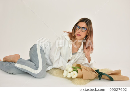 Bouquet of white tulips in a female hand on a white background. Bouquet of white tulips in a female hand on a white background. 99027602