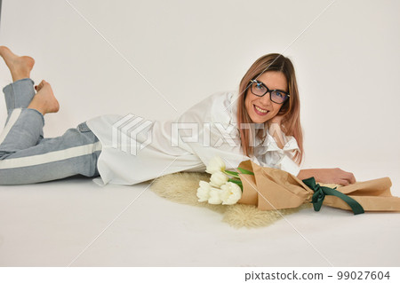 Bouquet of white tulips in a female hand on a white background. Bouquet of white tulips in a female hand on a white background. 99027604