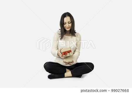 Young woman received a gift box for a special day and opening it with a happy face. Young woman received a gift box for a special day and opening it with a happy face. 99027668
