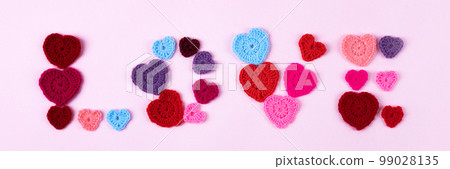 Happy Valentine's Day, Mother's Day and birthday greeting card. Multicolored crocheted hearts are laid out in the shape of a love on a lilac background. Banner Happy Valentine's Day, Mother's Day and birthday greeting card. Multicolored crocheted hearts are laid out in the shape of a love on a lilac background. Banner 99028135