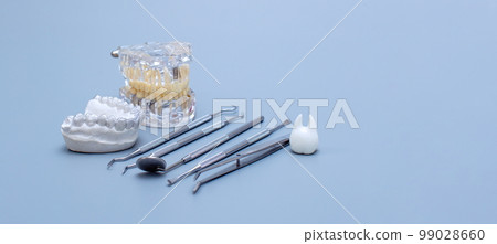 Dental tools and model of teeth on a blue background. Dental care concept. Invisible braces Dental tools and model of teeth on a blue background. Dental care concept. Invisible braces 99028660