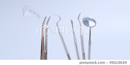 Dental tools and model of teeth on a blue background. Dental care concept. Invisible braces 99028689