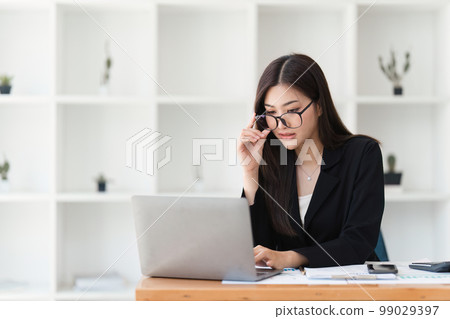 Asian Business woman working at home office and analyze financial report document. Accounting and Finance concept 99029397