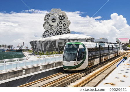View of the circular light rail train driving past Kaohsiung Music Center in Taiwan. View of the circular light rail train driving past Kaohsiung Music Center in Taiwan. 99029651