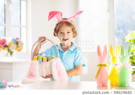 Kids on Easter egg hunt. Children dye eggs. 99029680