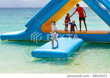 Kids on trampoline on tropical sea beach. Kids on trampoline on tropical sea beach. 99029871