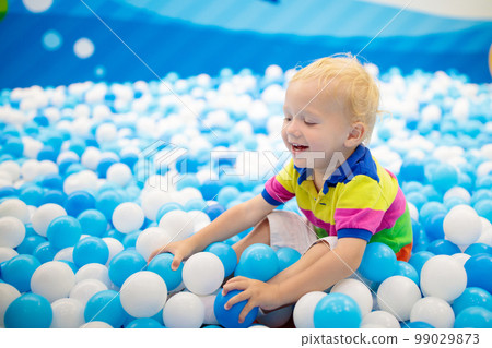 Kids play in ball pit. Child playing in balls pool Kids play in ball pit. Child playing in balls pool 99029873