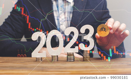 Businessman thinking about investing in cryptocurrency in 2023, choice between Ethereum and Bitcoin against the background of the chart 99030181