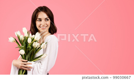 Smiling young european female with bouquet of tulips, enjoy lifestyle and rejoice in spring holiday Smiling young european female with bouquet of tulips, enjoy lifestyle and rejoice in spring holiday 99030667