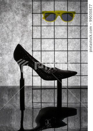 Still life with a woman's high-heeled shoe and glasses Still life with a woman's high-heeled shoe and glasses 99030877