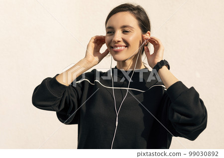 Cheerful caucasian millennial lady in sportswear and headphones enjoys fitness and jogging 99030892