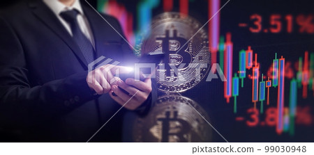 Smartphone with Bitcoin trading chart . Holding in hand a gold Bitcoin Cash coin. Trading on the cryptocurrency exchange. 99030948