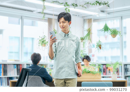 在辦公室工作的穿著便衣的年輕男商人 99031270