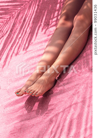 Female feet on the sand, toned in pink Female feet on the sand, toned in pink 99031436