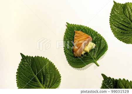 Salmon sashimi and garlic on top of fresh sesame leaves Salmon sashimi and garlic on top of fresh sesame leaves 99031529