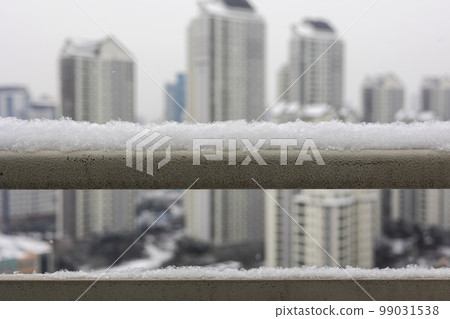 冬季大雪堆積在欄杆上的雪與城市高層公寓樓的景色 冬季大雪堆積在欄杆上的雪與城市高層公寓樓的景色 99031538