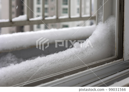 冬季大雪堆積在欄杆和窗台上的雪與城市高層公寓樓的景色 冬季大雪堆積在欄杆和窗台上的雪與城市高層公寓樓的景色 99031566