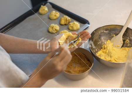 Spreading the dough with your hands and adding sugar Spreading the dough with your hands and adding sugar 99031584
