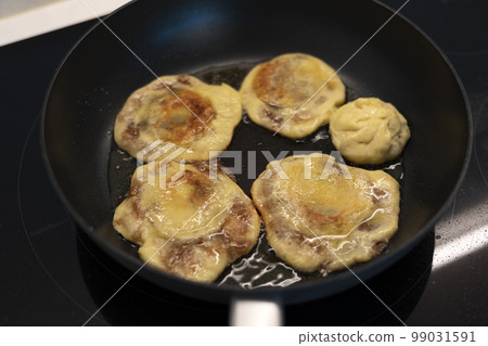 Baking hotteok pancakes in an oiled frying pan Baking hotteok pancakes in an oiled frying pan 99031591
