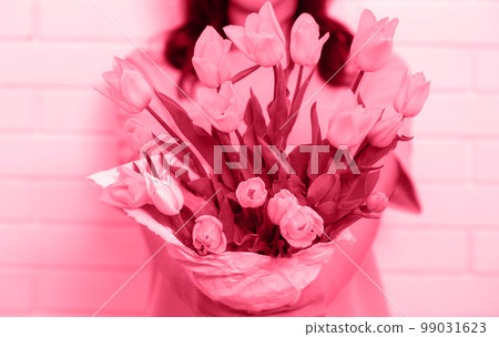 Bouquet of tulips in hands, toned in pink Bouquet of tulips in hands, toned in pink 99031623