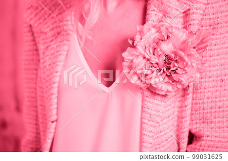 A pink tweed jacket with a brooch in the shape of a flower, toned in pink A pink tweed jacket with a brooch in the shape of a flower, toned in pink 99031625