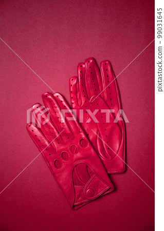 bright red gloves with holes on a red background bright red gloves with holes on a red background 99031645