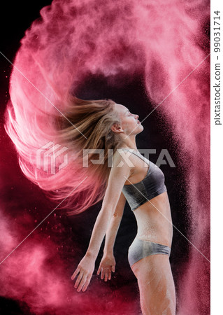 The woman waves her hair, toned in pink 99031714