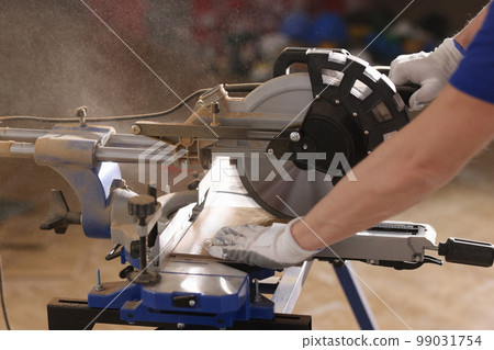 Close up of handyman cuts wooden board with circular saw. Close up of handyman cuts wooden board with circular saw. 99031754