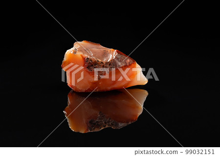 Carnelian Uncut Gem Stone on Black Background Carnelian Uncut Gem Stone on Black Background 99032151