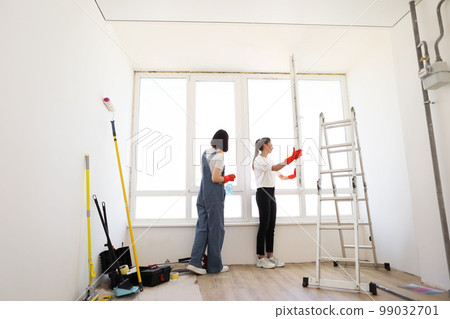 Attractive caucasian girls making house cleaning after repair. Attractive caucasian girls making house cleaning after repair. 99032701