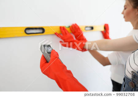 Laser rangefinder or laser tape measure in a female hand. Laser rangefinder or laser tape measure in a female hand. 99032708