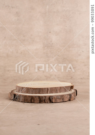 Round wooden saw cut cylinder shape for product presentation on a beige background Round wooden saw cut cylinder shape for product presentation on a beige background 99033891