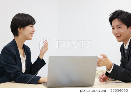 A business woman proposing and a businessman looking at a PC 99034060
