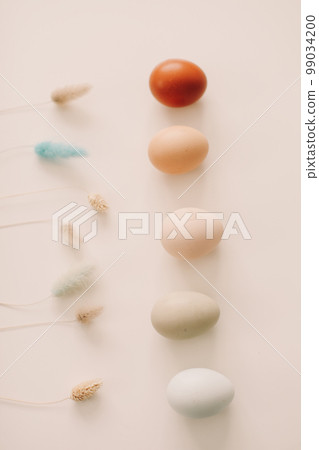 Happy Easter concept. Fresh chicken eggs of natural shades and colors on a white background Happy Easter concept. Fresh chicken eggs of natural shades and colors on a white background 99034200