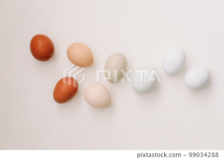 Happy Easter concept. Fresh chicken eggs of natural shades and colors on a white background 99034288